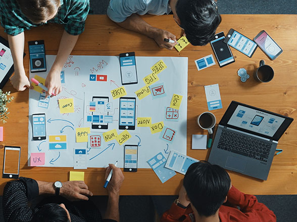 Digital marketing team gathered around desk developing strategies to help home services win more customers.